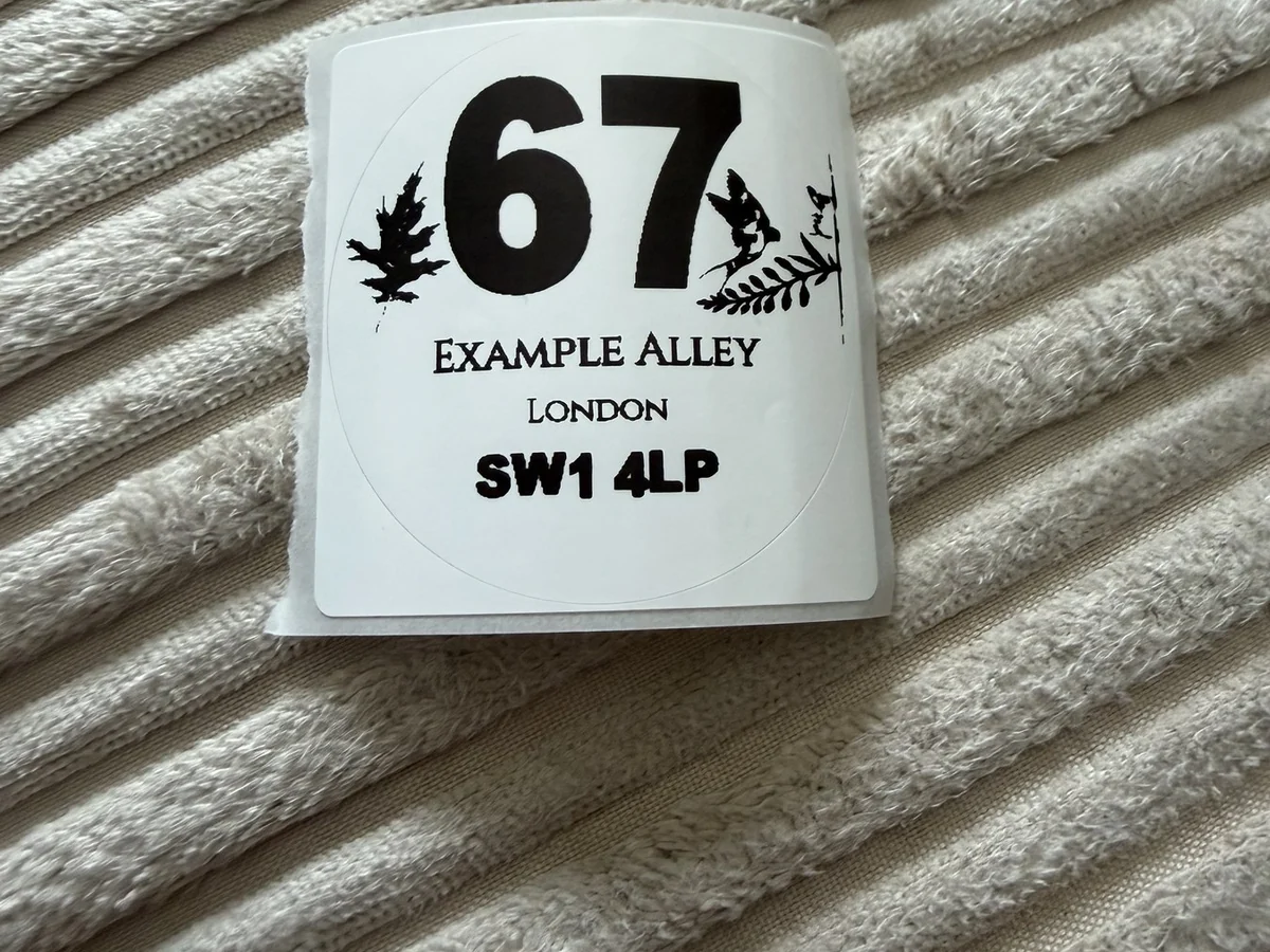 Close-up of a personalised wheelie bin sticker roll with example address text